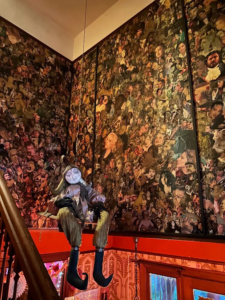 Collage mural and hanging puppet decor near the staircase at Rimsky-Korsakoffee House